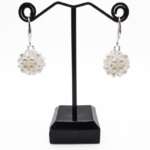 White pearl and clear crystal cluster earrings displayed on black jewellery stand