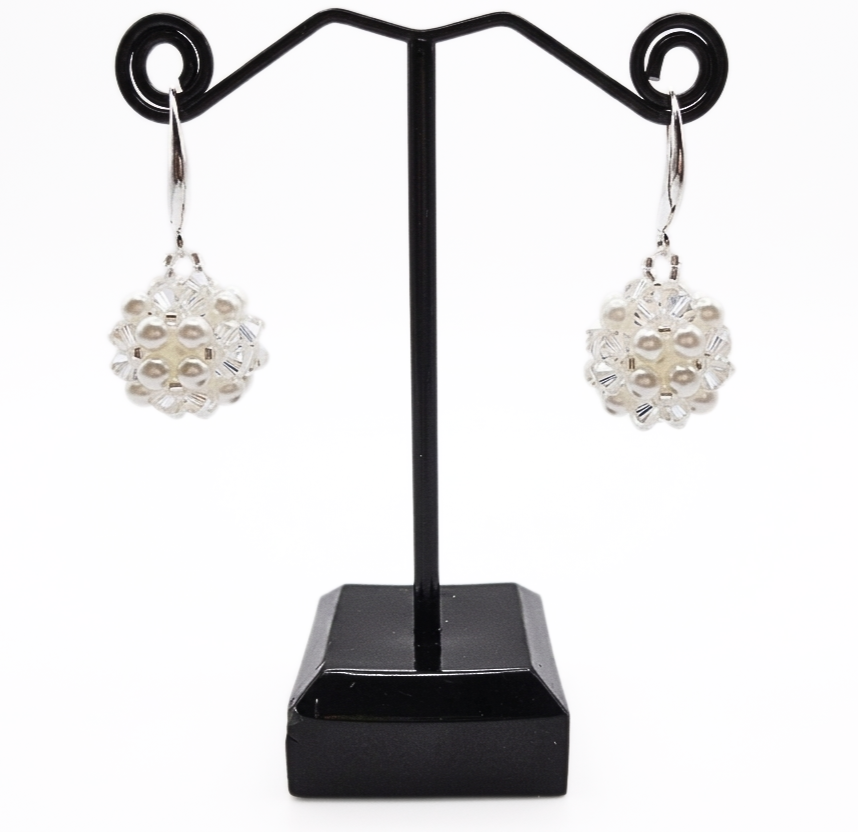 White pearl and clear crystal cluster earrings displayed on black jewellery stand