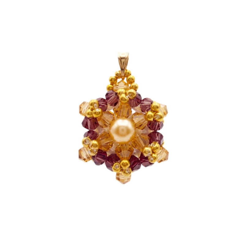 Crystal and pearl pendant with a champagne centre pearl surrounded by warm champagne faceted crystals and an outer purple crystals, accented throughout with gold beads, displayed against a white background.
