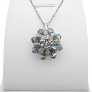 Handmade grey crystal AB flower pendant with two layers of iridescent grey-blue aurora borealis faceted crystals and a sparkling cubic zirconia centre, displayed on a silver-tone chain and white jewellery stand.
