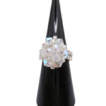 Handmade clear AB crystal cluster cocktail ring on black cone ring stand — iridescent aurora borealis crystals and silver-tone seed beads, handcrafted statement ring