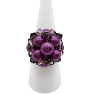 Purple pearl cluster cocktail ring with violet crystal accents displayed on white ring cone stand - handmade beaded statement ring