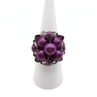 Purple pearl cluster cocktail ring with violet crystal accents displayed on white ring cone stand - handmade beaded statement ring