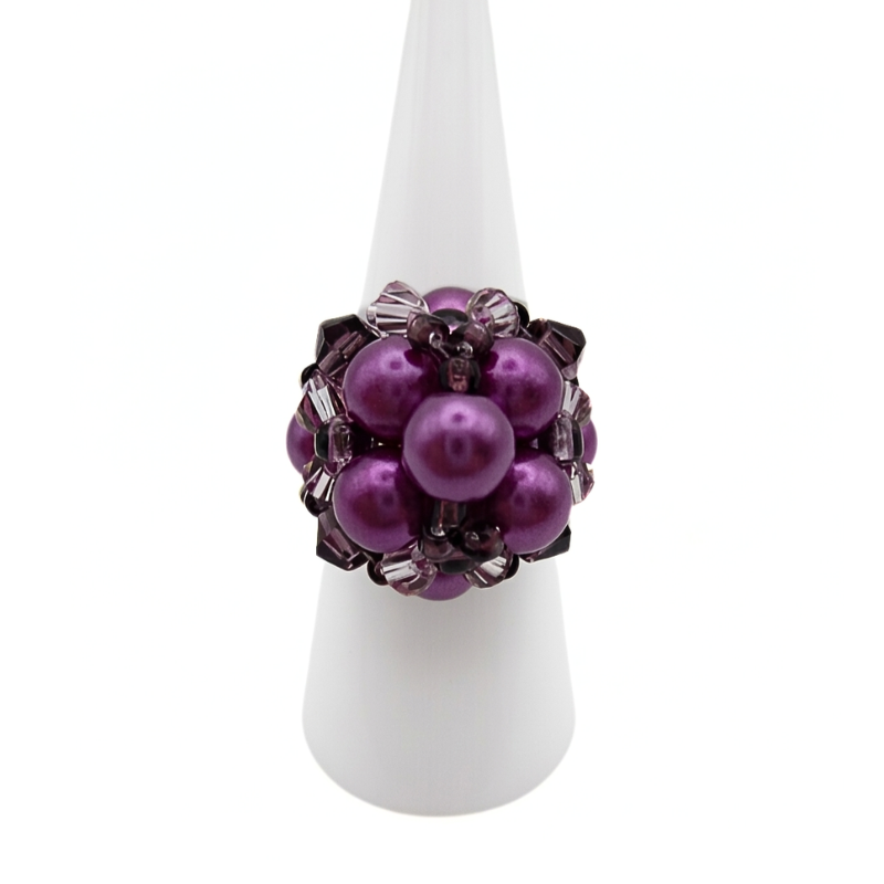 Purple pearl cluster cocktail ring with violet crystal accents displayed on white ring cone stand - handmade beaded statement ring
