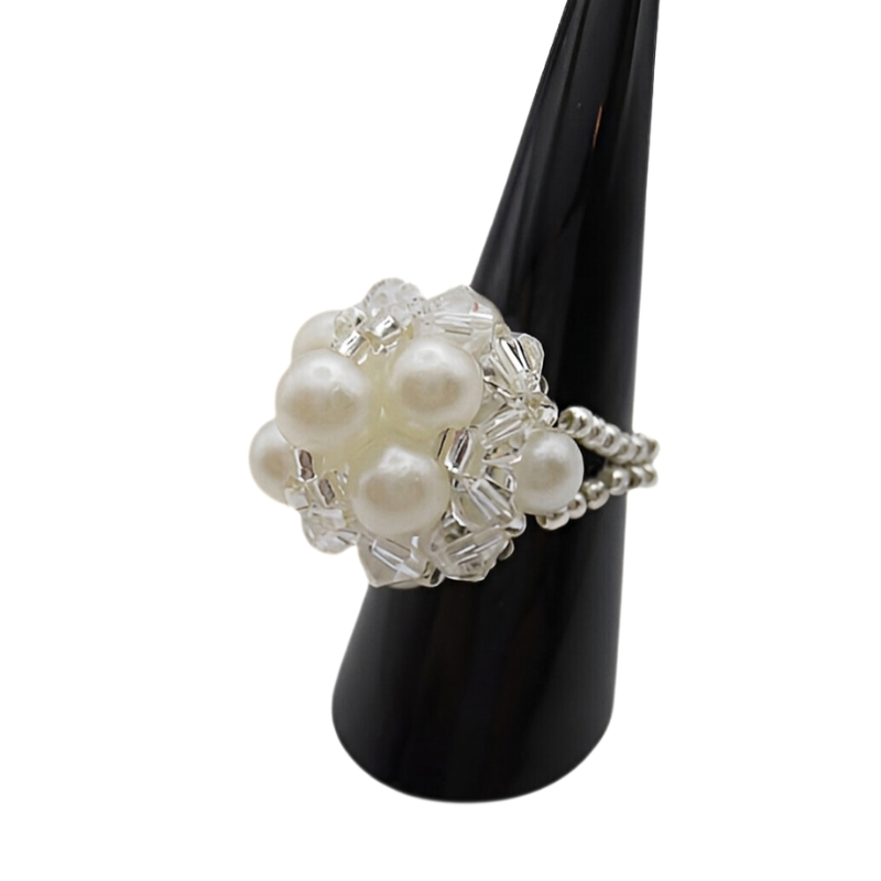 Side view of white pearl cluster ring with clear crystal beads and silver beaded stretch band on black ring stand - handmade bridal jewellery.