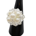 Angled side view of handmade white pearl and clear crystal cluster cocktail ring on black display cone - bridal beaded statement ring