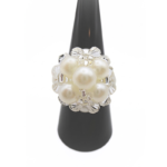 White pearl cluster cocktail ring with clear crystal accents displayed on black ring cone stand - handmade beaded statement ring, shown against a white background