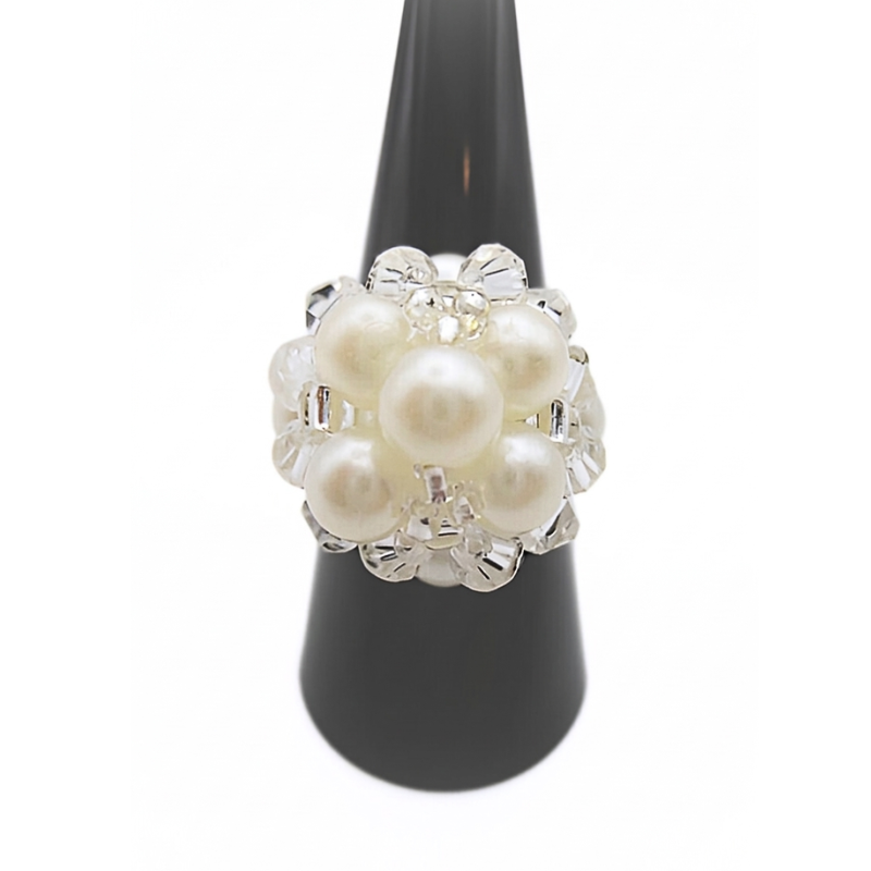 White pearl cluster cocktail ring with clear crystal accents displayed on black ring cone stand - handmade beaded statement ring, shown against a white background
