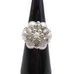 Handmade cluster ring featuring white pearl beads, faceted light grey crystal beads, and silver-tone metal accents, displayed on a black ring cone — front view