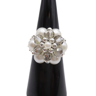 Handmade cluster ring featuring white pearl beads, faceted light grey crystal beads, and silver-tone metal accents, displayed on a black ring cone — front view