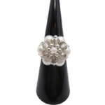 Handmade cluster ring featuring white pearl beads, faceted light grey crystal beads, and silver-tone metal accents, displayed on a black ring cone, shown against a white background