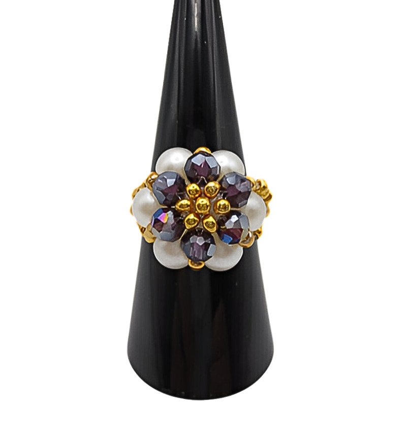 pearl-crystal-ring-purple-front Front view of a handmade floral cluster ring with white pearl beads, faceted purple AB iridescent crystal beads, and gold-tone metal accents, displayed on a black ring cone