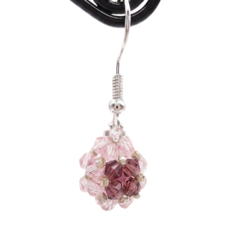 Side view of handmade pink and purple crystal beaded ball drop earring on display stand, silver ear hook wire, shown against a white background.