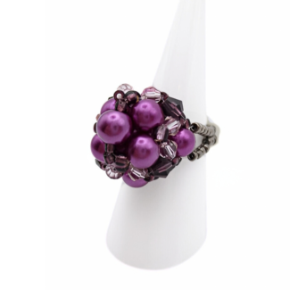 Side view of handmade purple pearl cluster ring with violet crystal beads and beaded band on white display stand