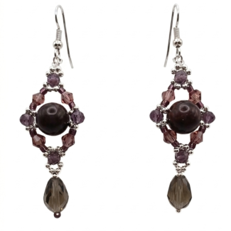 Handmade chandelier drop earrings featuring a dark tourmaline stone centre surrounded by purple and mauve crystals in a diamond frame, with a faceted smoky grey crystal teardrop and silver-tone ear wires, on white background.