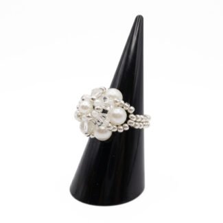 Side view of handmade pearl and crystal cluster ring displayed on black cone ring stand — white pearls, clear crystals, and silver-tone seed beads