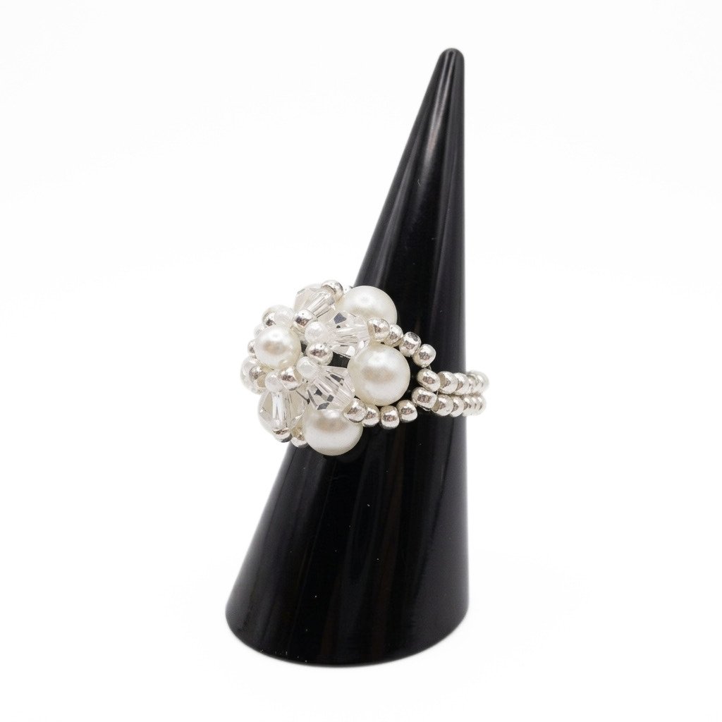 white-pearl-crystal-ring-side-view Side view of handmade pearl and crystal cluster ring displayed on black cone ring stand — white pearls, clear crystals, and silver-tone seed beads