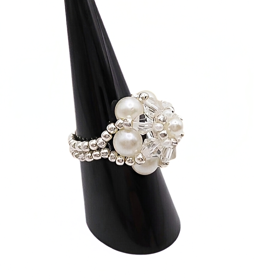 Side view of handmade pearl and crystal cluster ring displayed on black cone ring stand — white pearls, clear crystals, and silver-tone seed beads