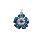 Handmade floral pendant featuring white pearls and a blue pearl centre accent surrounded by metallic blue crystals and aquamarine bead detailing, with a silver-tone bail, photographed on a white background.