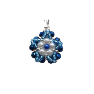 Handmade floral pendant featuring white pearls and a blue pearl centre accent surrounded by metallic blue crystals and aquamarine bead detailing, with a silver-tone bail, photographed on a white background.