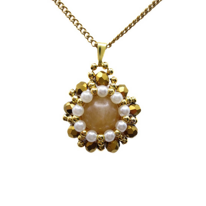Close-up view of reversible tourmaline pendant featuring a smooth round peach tourmaline centre stone surrounded by white freshwater-style pearls and metallic gold faceted crystals with gold seed bead accents, displayed on a gold-tone curb chain against a white background.
