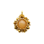Handmade reversible tourmaline pendant front view featuring a smooth round peach tourmaline centre stone encircled by metallic gold-plated faceted crystals and gold bead accents in a sunburst floral design, with a gold-tone bail, photographed against a white background.