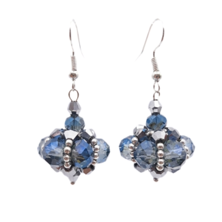 Close-up of handmade drop earrings with translucent blue and smoky-grey faceted crystals and metallic silver crystals woven into a pendulum cluster shape, with silver seed bead accents and silver-toned ear wires, on white background