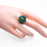 Olive green tourmaline and teal crystal beaded statement ring worn on a ring finger, showing scale and wearability of handmade boho cocktail ring