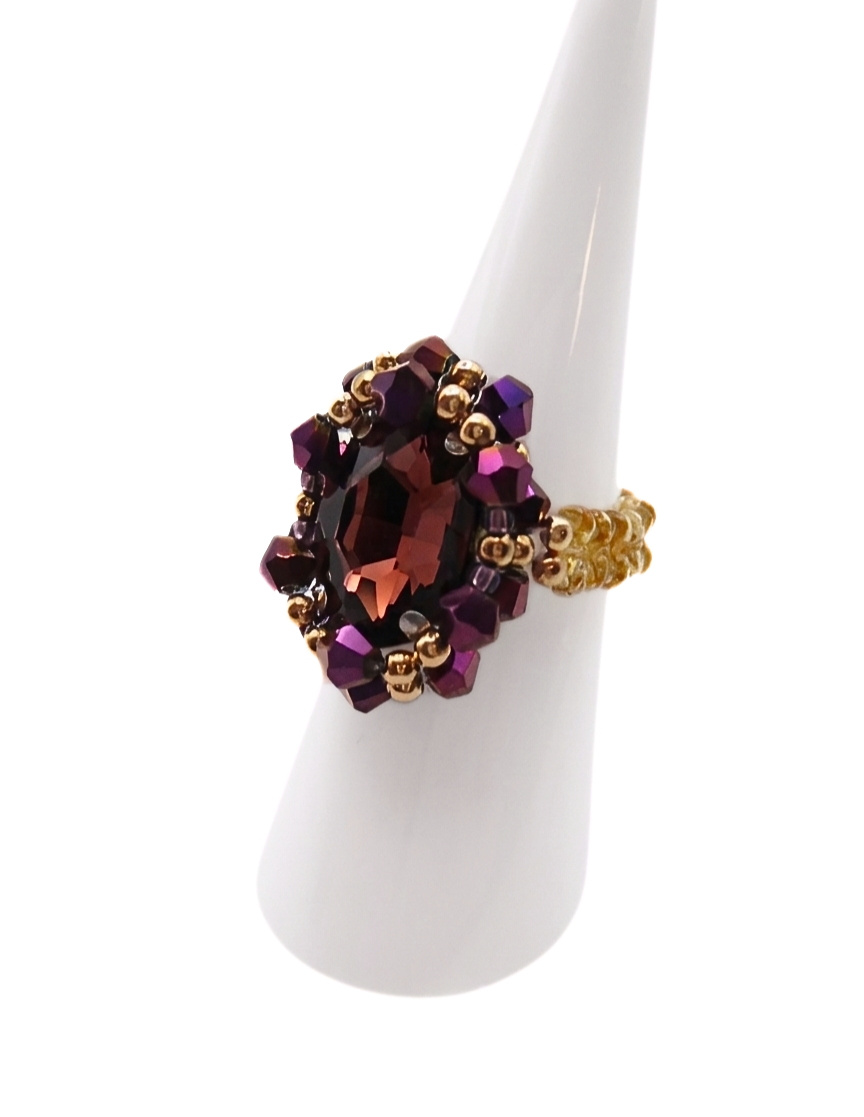 Side view of handmade purple and gold beaded cocktail ring on white display stand - crystal dress ring for women