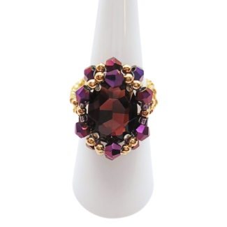 Handmade purple crystal cocktail ring with gold-tone beads on white ring display stand - statement beaded ring