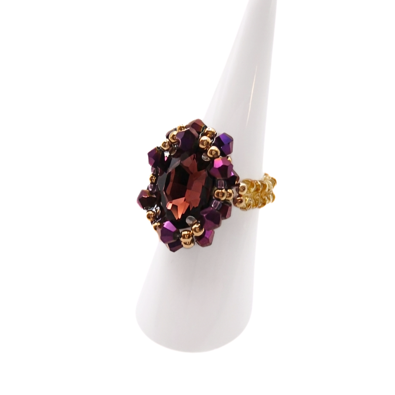 purple-crystal-ring-side-view Side view of handmade purple and gold beaded cocktail ring on white display stand - crystal dress ring for women