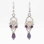 Handmade purple amethyst crystal and white pearl dangle earrings with silver-tone beaded frame and teardrop crystal, shown against a white background