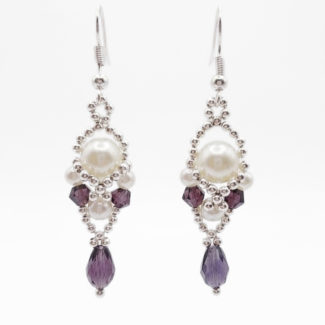 Handmade purple amethyst crystal and white pearl dangle earrings with silver-tone beaded frame and teardrop crystal, shown against a white background
