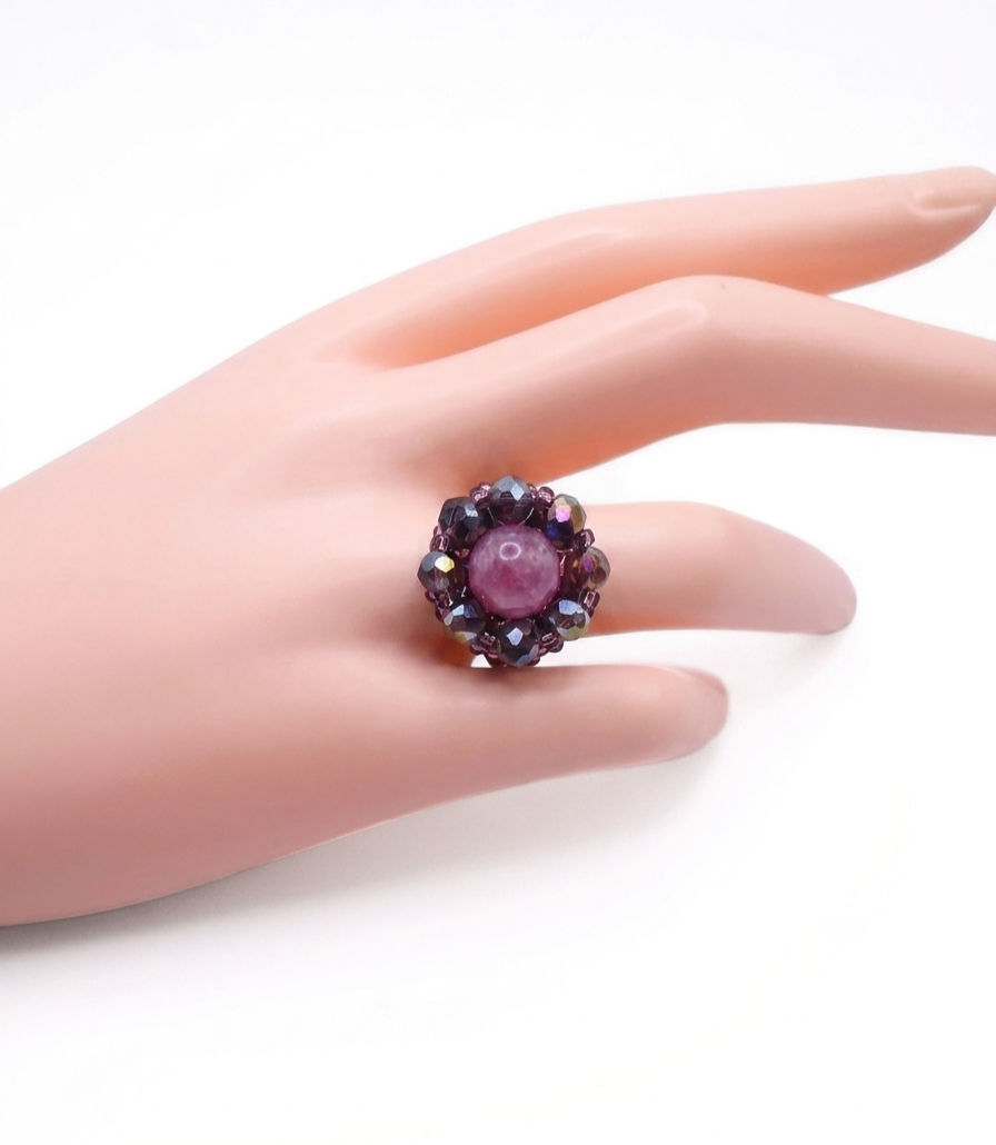 rose-tourmaline-ring-hand-display Rose pink tourmaline and purple AB crystal beaded statement ring worn on a middle finger, showing size and wearability of handmade floral cocktail ring against a light background