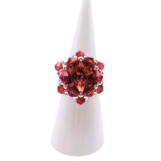 Red crystal cluster cocktail ring with large center crystal on white ring cone stand — handmade beaded statement ring