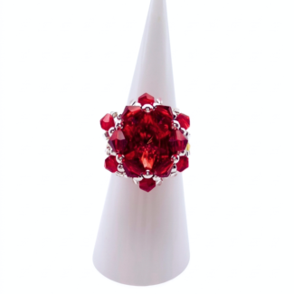 Red crystal cluster cocktail ring with large center crystal on white ring cone stand — handmade beaded statement ring