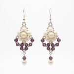 Off-white pearl and amethyst purple crystal drop earrings with faceted purple crystals, silver-toned bead detailing and dangling pearl accents.