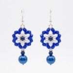 Pair of elegant blue pearl and crystal earrings with soft ivory & deep blue pearls, faceted sapphire blue crystals, and dangling blue pearl drops on a white background.