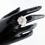 Handmade crystal cluster ring with pearl accents modeled on a display hand, close-up view