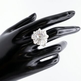 Handmade crystal cluster ring with pearl accents modeled on a display hand, close-up view