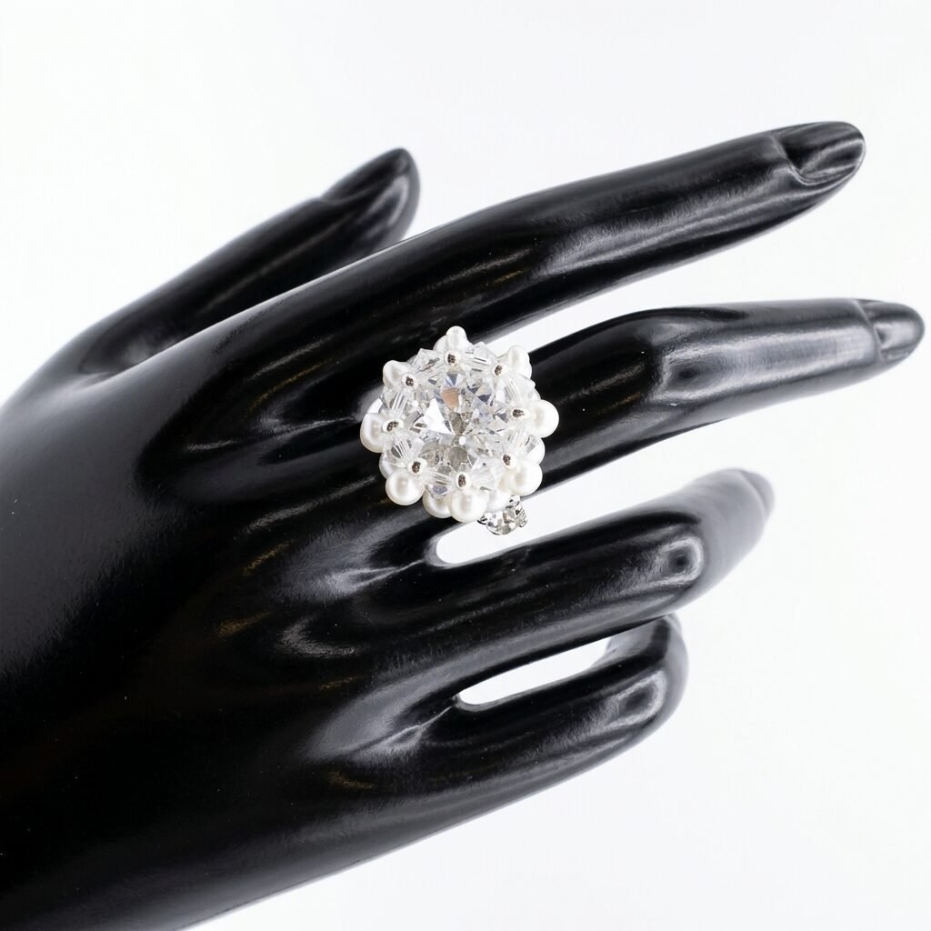 crystal-pearl-statement-ring-display Handmade crystal cluster ring with pearl accents modeled on a display hand, close-up view