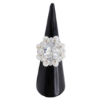 Sparkling crystal cluster ring with large center stone, surrounding clear AB crystals, white pearls, and silver accents on a ring cone. Shown against a white background