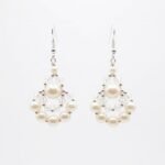 Clear crystal and off-white faux pearl drop earrings with silver-tone detailing, handmade statement pearl earrings on a off-white background