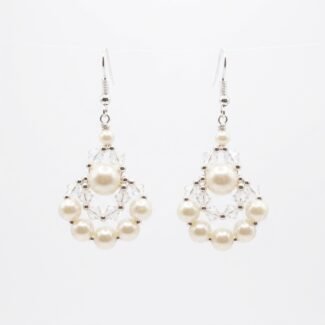 Clear crystal and off-white faux pearl drop earrings with silver-tone detailing, handmade statement pearl earrings on a off-white background