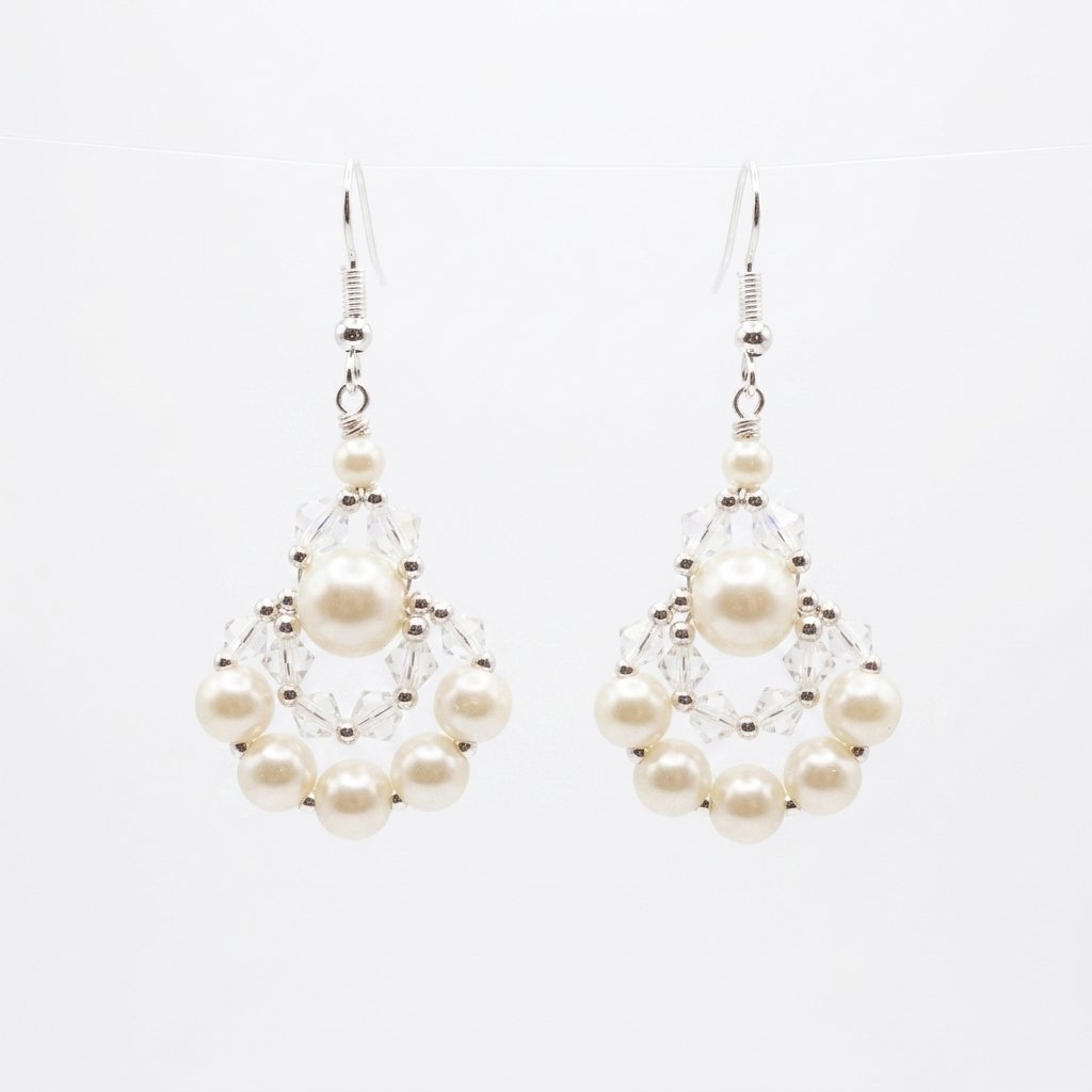 elegant-pearl-crystal-earrings Clear crystal and off-white faux pearl drop earrings with silver-tone detailing, handmade statement pearl earrings on a off-white background