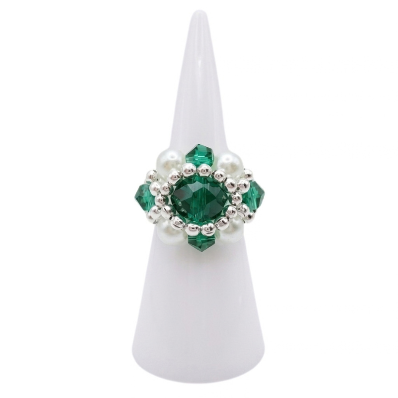 Emerald green crystal ring with white pearl and silver beaded design on white ring display, shown against a white background