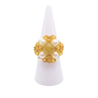 Handmade golden crystal and white pearl ring with tourmaline centre stone displayed on a white ring cone, shown against a white background.