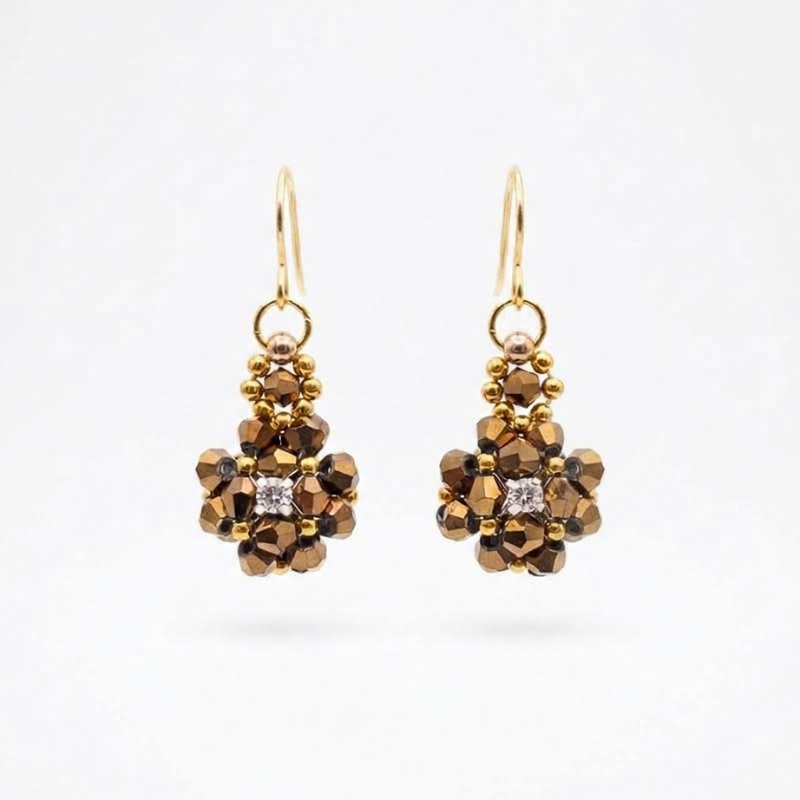 metallic-bronze-crystal-earrings Metallic bronze crystal cluster earrings with sparkling cubic zirconia centre, and gold-tone ear wires on a neutral background
