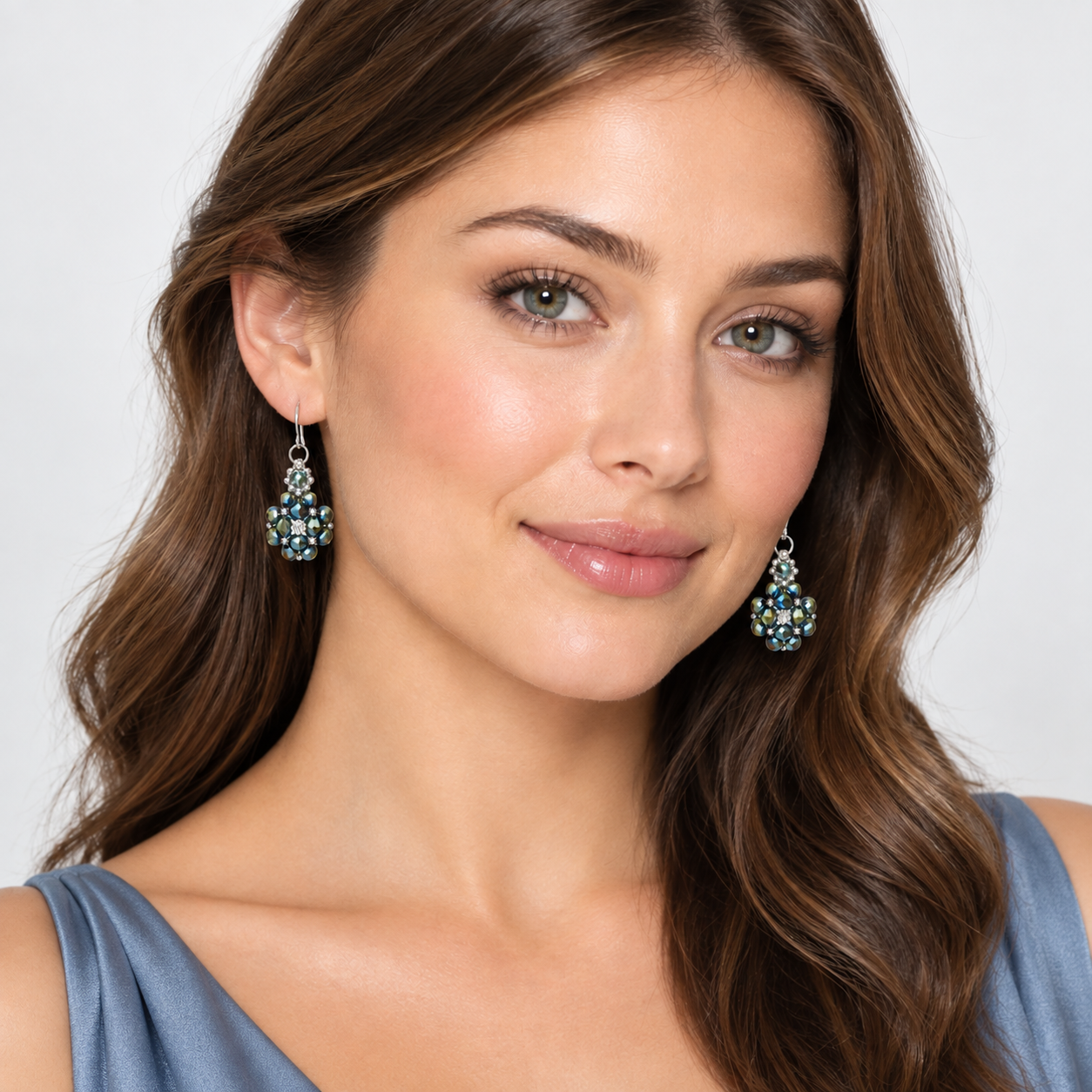 metallic-crystal-earrings-model A model wearing multi-metallic crystal cluster earrings with sparkling cubic zirconia centre, shown against a neutral background
