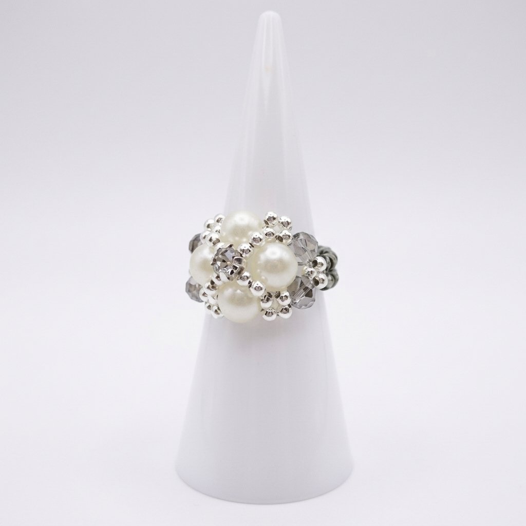 pearl-smoky-crystal-ring-display White pearl and smoky grey crystal beaded cocktail ring with silver accents, displayed on a ring cone - side view.